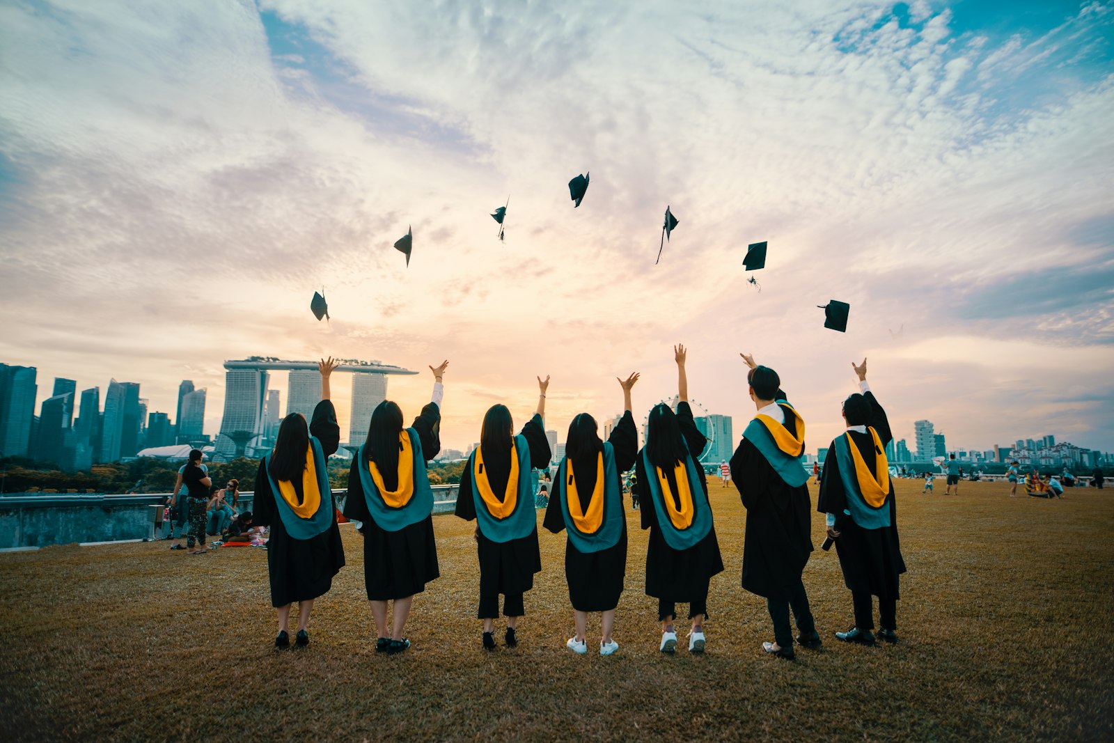 Graduates throwing caps into the air at sunset