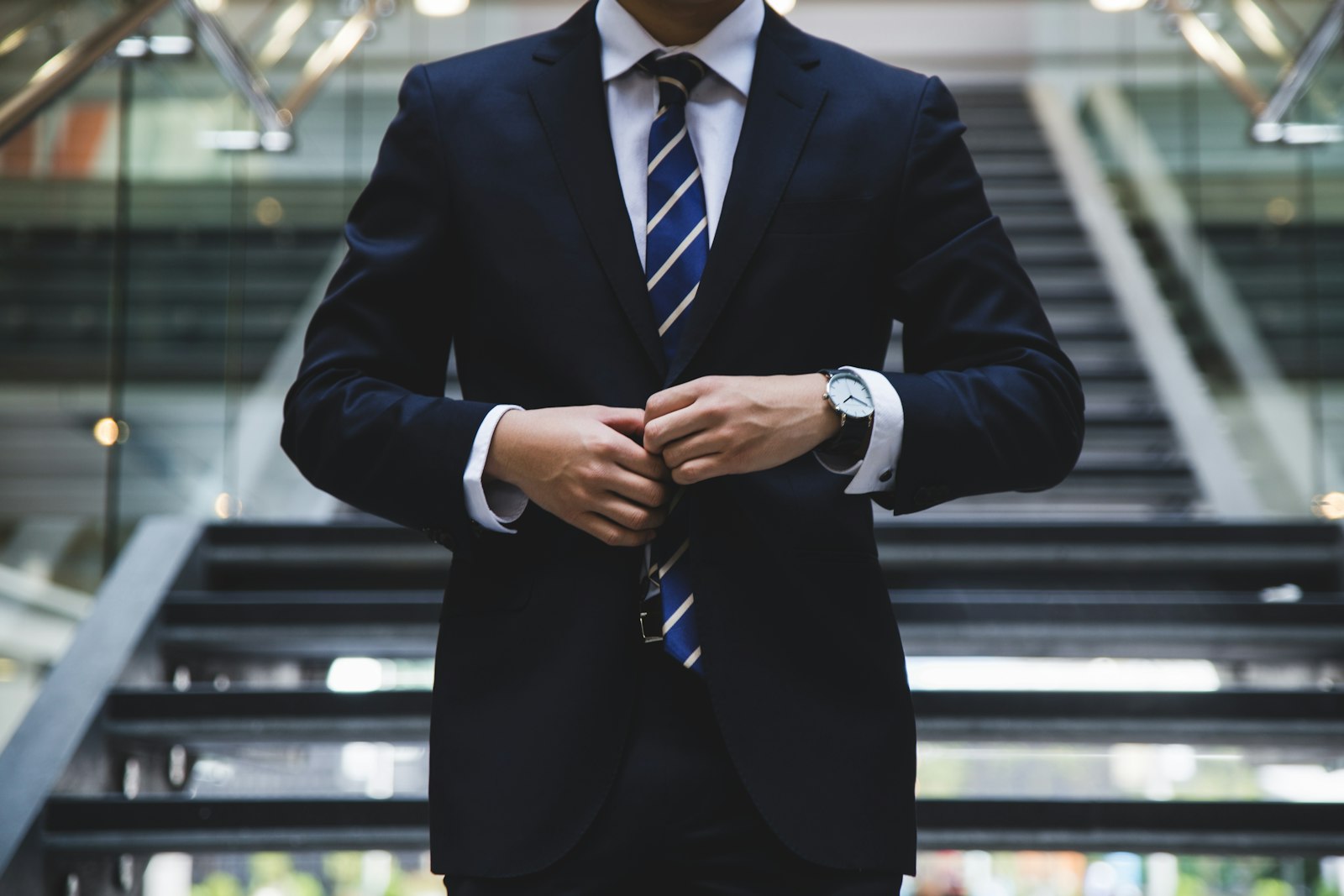 Senior executive in a dark suit adjusting his jacket