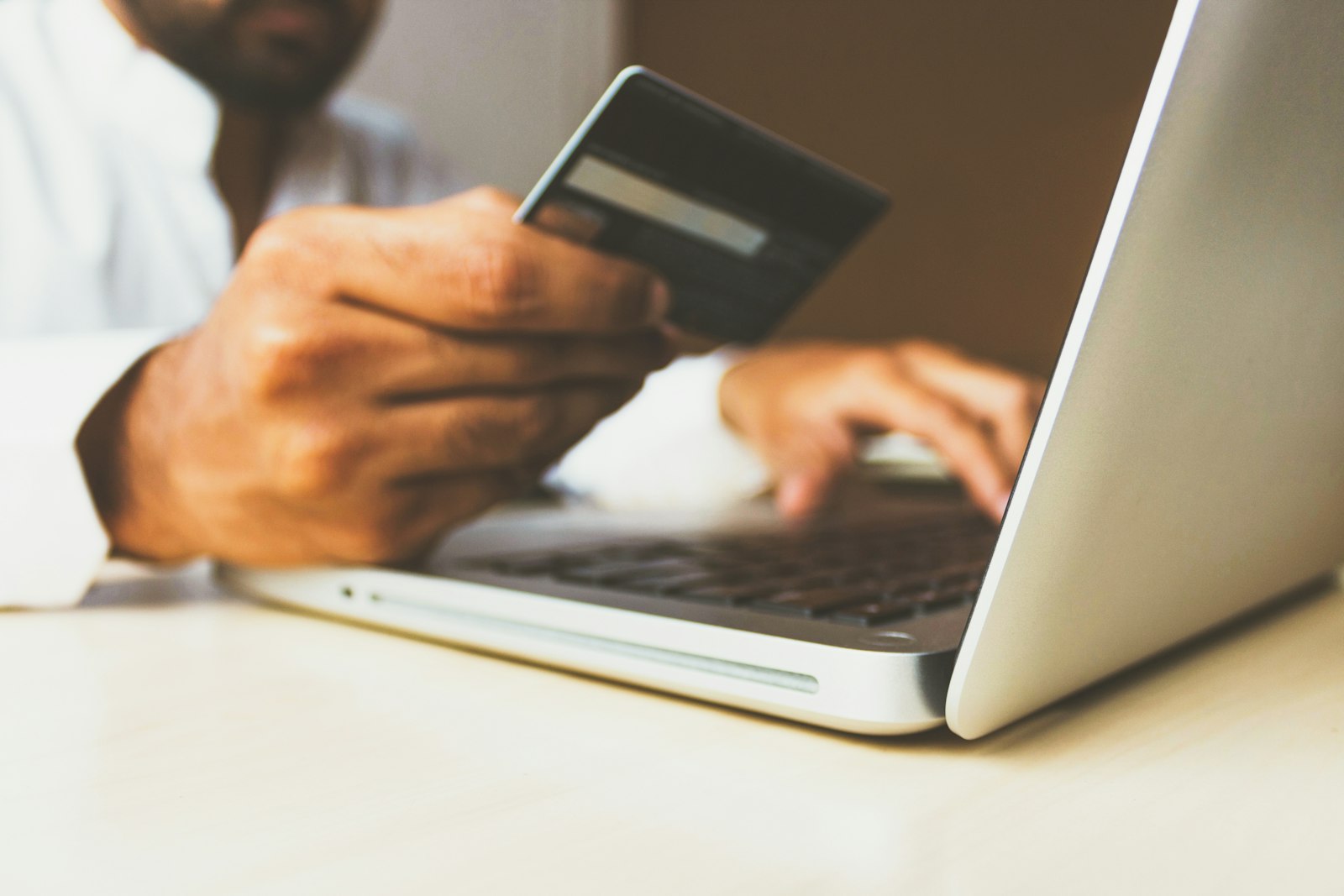 Hands entering credit card details on a laptop